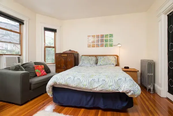 a bedroom with a bed and wooden floor