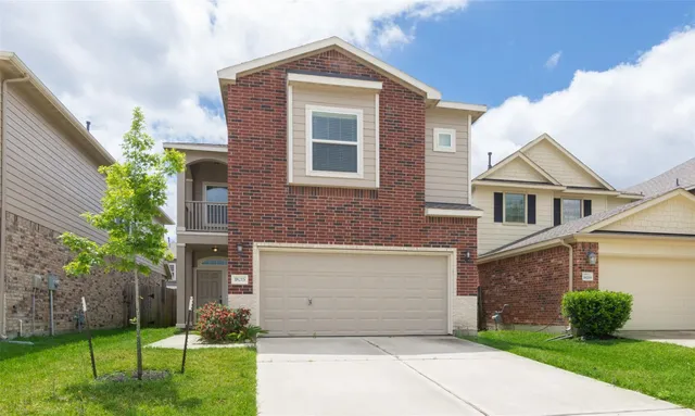 a front view of a house with a yard and garage