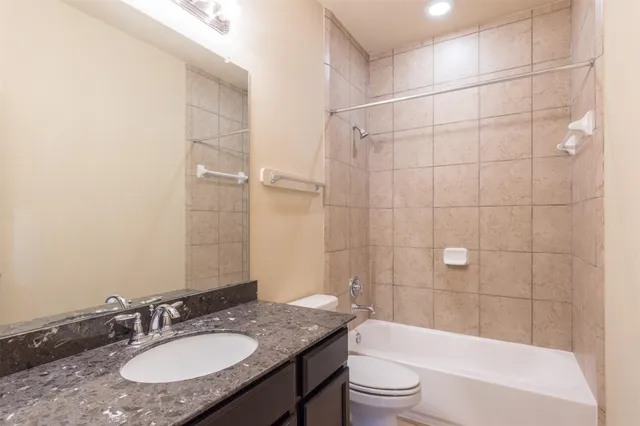 a bathroom with a granite countertop sink toilet tub and shower