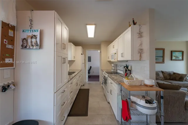 a kitchen with stainless steel appliances granite countertop a refrigerator a stove and a sink