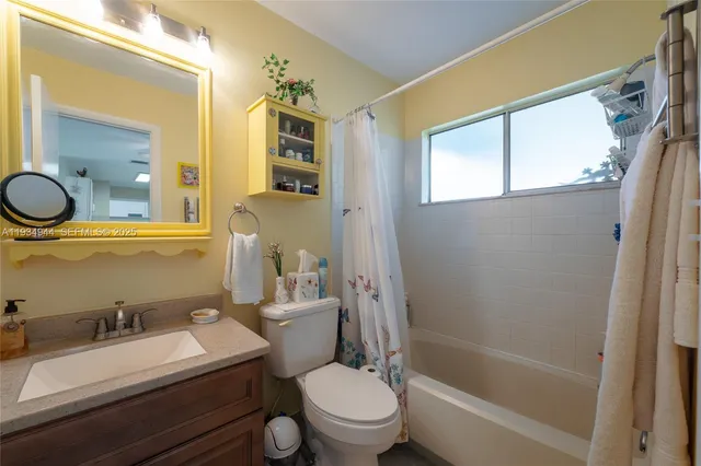 a bathroom with a sink a toilet a mirror and shower