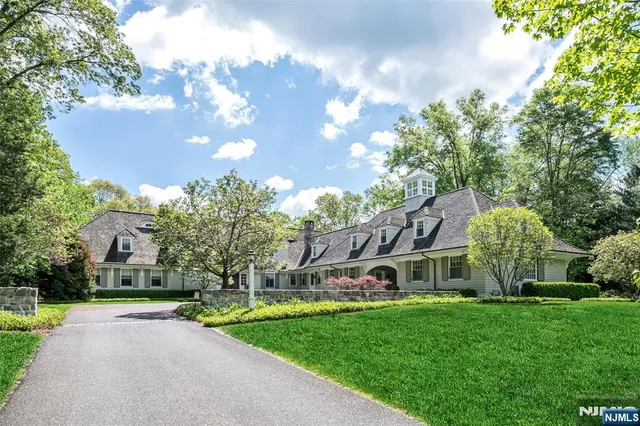 a view of a house with a big yard plants and large trees