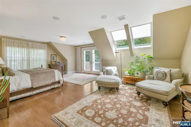 a bedroom with a bed and a large window