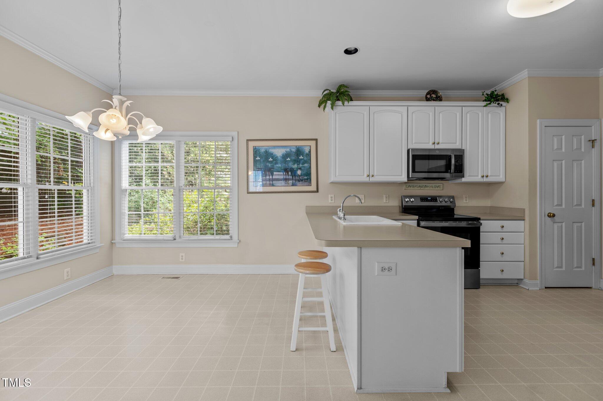 1224 Wedgeland Drive Raleigh, NC 27615 - Photo 11 of 36 a kitchen with stainless steel appliances a stove refrigerator sink and microwave
