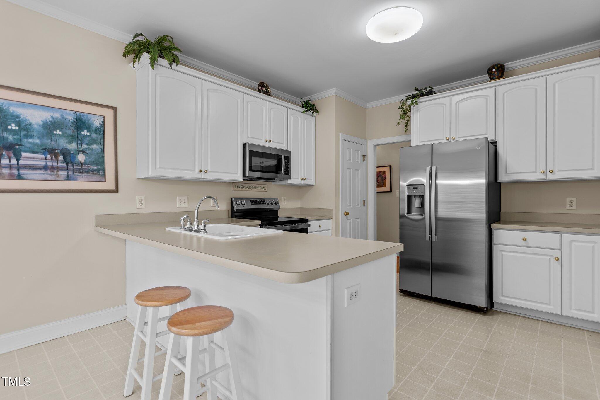 1224 Wedgeland Drive Raleigh, NC 27615 - Photo 14 of 36 a kitchen with stainless steel appliances a microwave sink refrigerator and cabinets