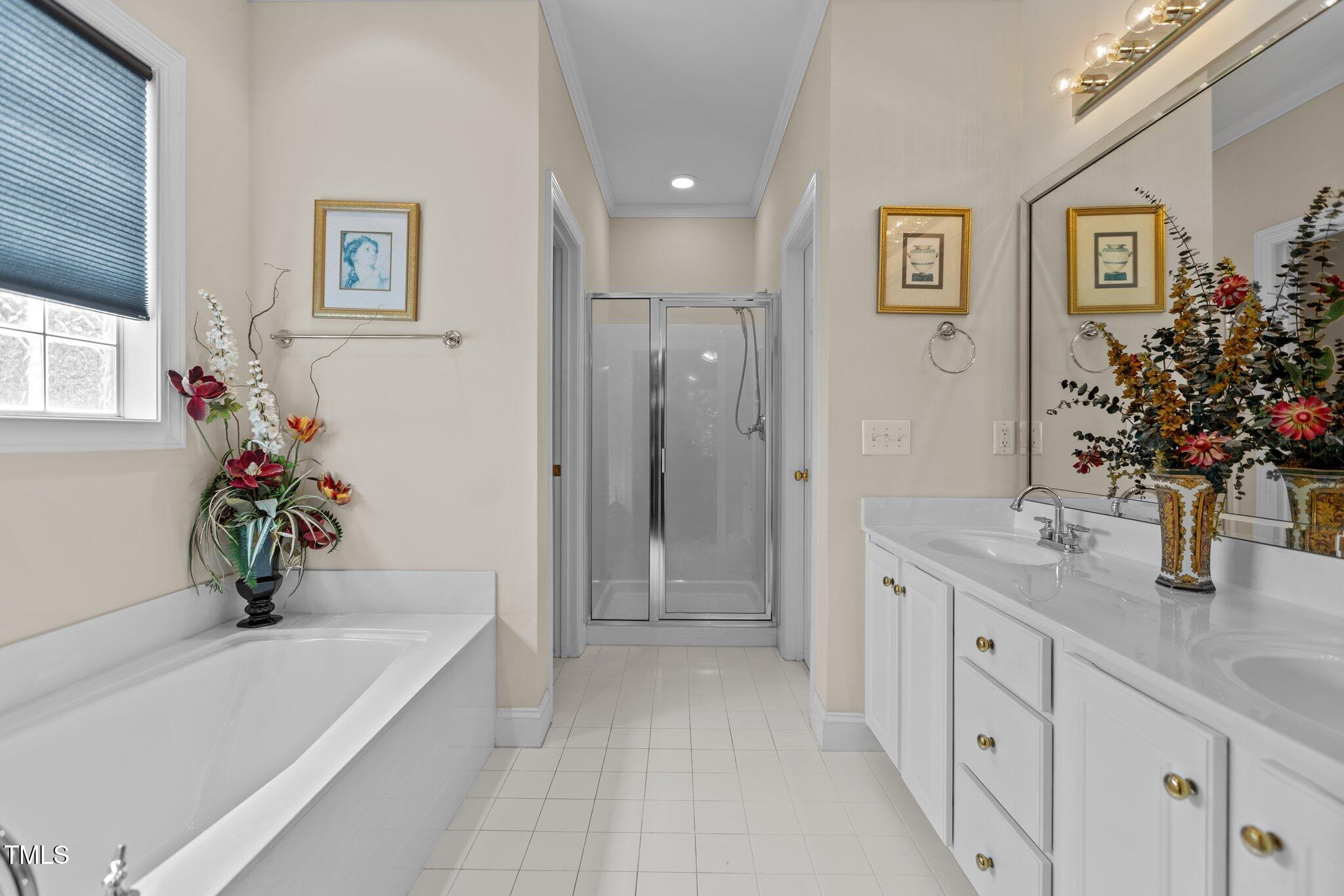 1224 Wedgeland Drive Raleigh, NC 27615 - Photo 22 of 36 a bathroom with a tub a sink and a large mirror