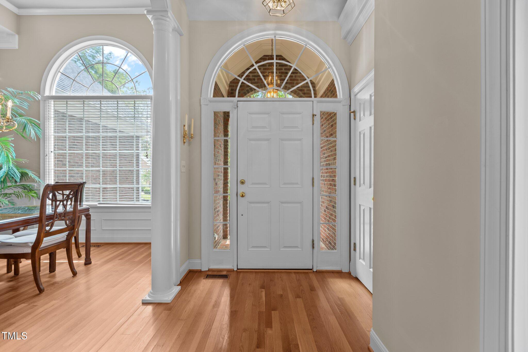 1224 Wedgeland Drive Raleigh, NC 27615 - Photo 3 of 36 an empty room with wooden floor a glass door and windows