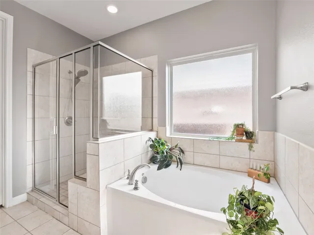 a spacious bathroom with a bathtub sink and mirror