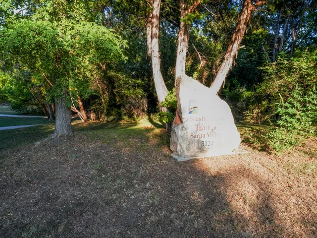 a view of a house with a yard and a tree