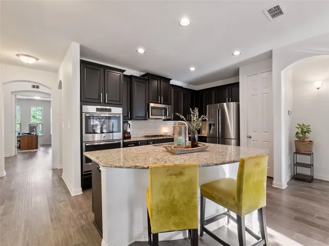 a kitchen with stainless steel appliances granite countertop sink microwave and wooden floor