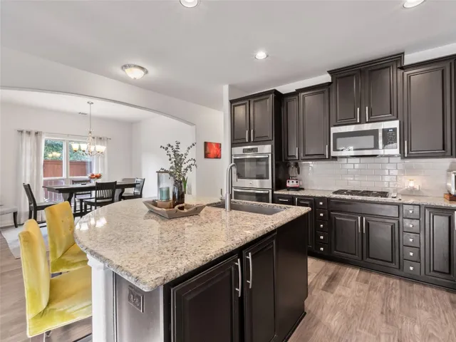 a kitchen with kitchen island granite countertop a sink and cabinets