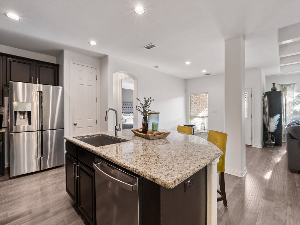 1101 Feather Reed Drive Leander, TX 78641 - Photo 7 of 40 a kitchen with stainless steel appliances granite countertop kitchen island wooden cabinets a refrigerator and stove