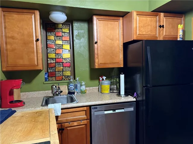 a kitchen with stainless steel appliances a sink cabinets and a window