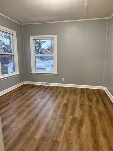 a view of room with window and wooden floor