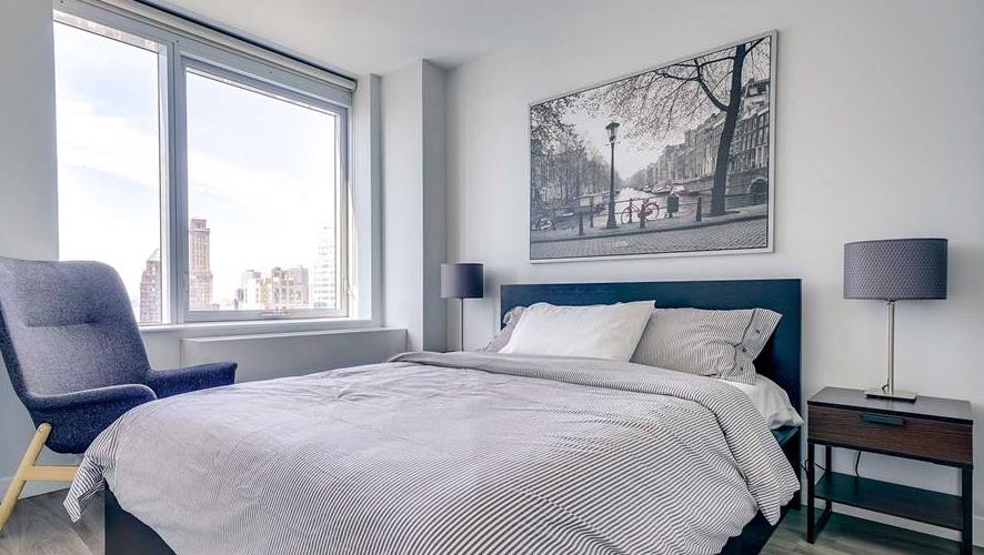 100 Willoughby Street, Unit 28Q Brooklyn, NY 11201 - Photo 3 of 10 a bedroom with a bed and a painting on the wall