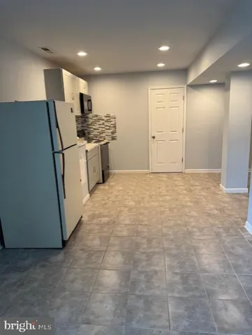 a kitchen with a sink a refrigerator and cabinets