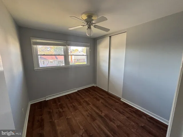 an empty room with windows and fan