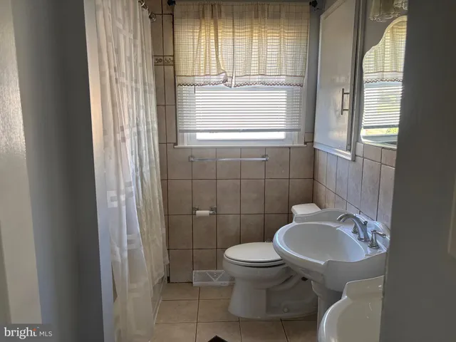 a bathroom with a toilet a sink and a window