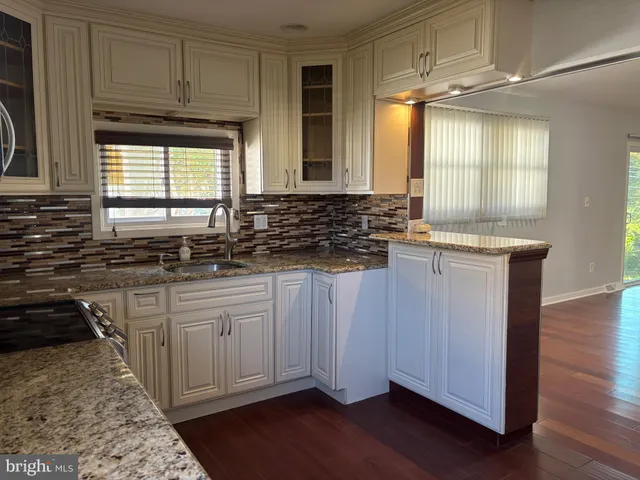 a kitchen with granite countertop a sink and a stove