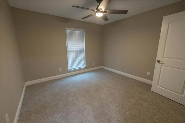 an empty room with closet and a chandelier fan