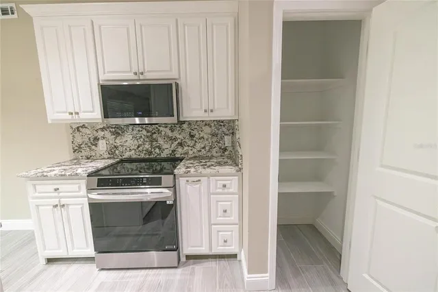 a kitchen with stainless steel appliances granite countertop a stove and a microwave