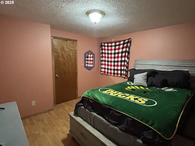a bedroom with a bed and a flat tv screen on the dresser