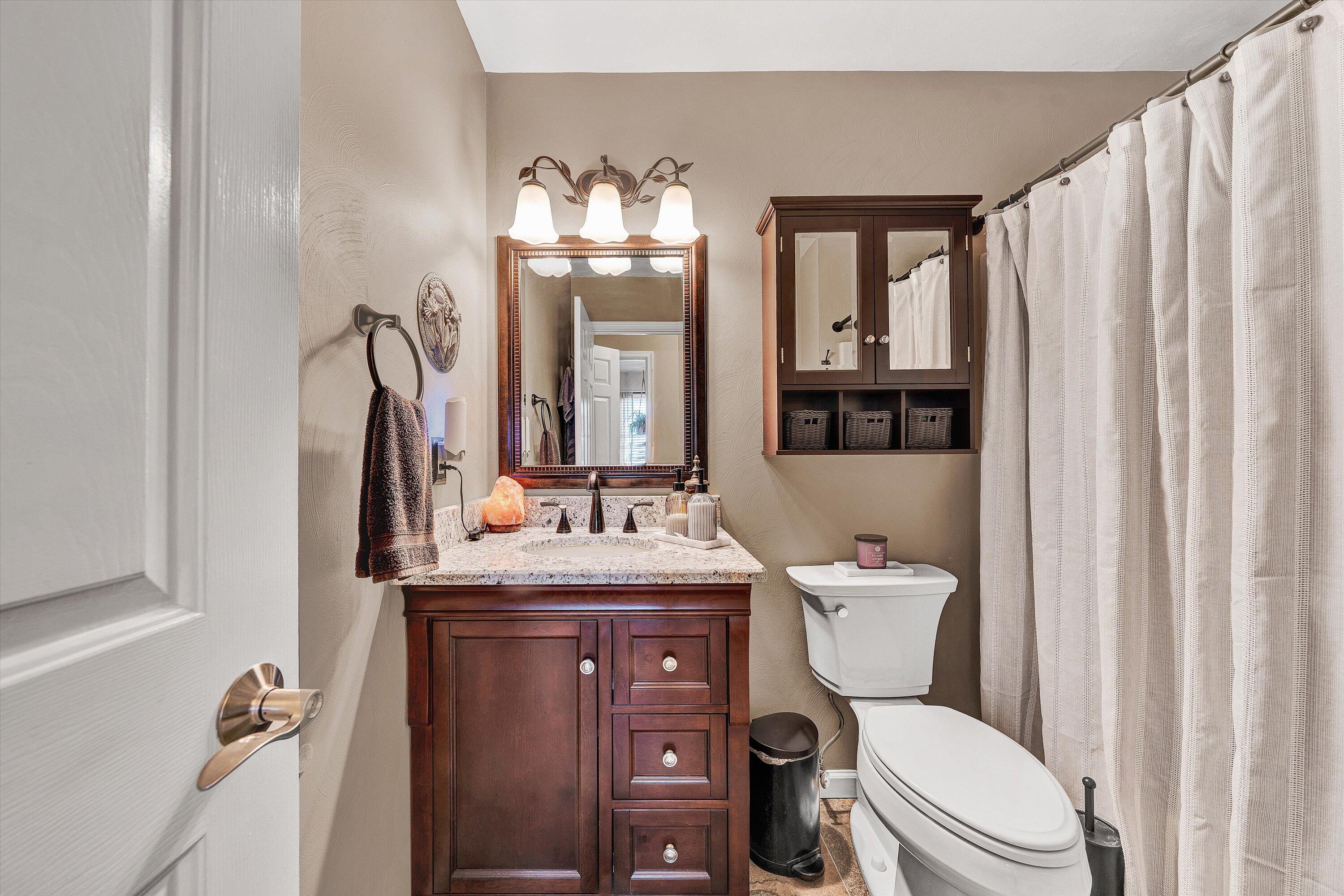 1160 Sandy Level Road Goodview, VA 24095 - Photo 14 of 47 a bathroom with a granite countertop toilet sink and mirror