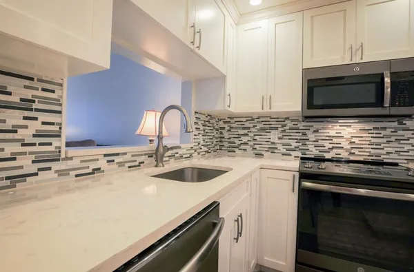 a kitchen with stainless steel appliances a refrigerator sink and stove