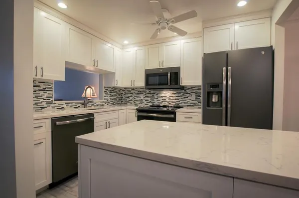 a kitchen with stainless steel appliances white cabinets and a refrigerator