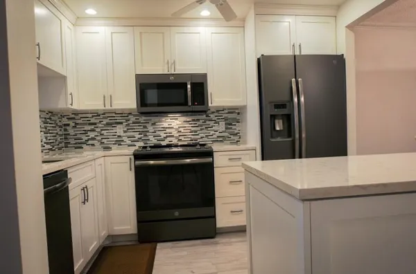 a kitchen with stainless steel appliances a stove microwave and sink