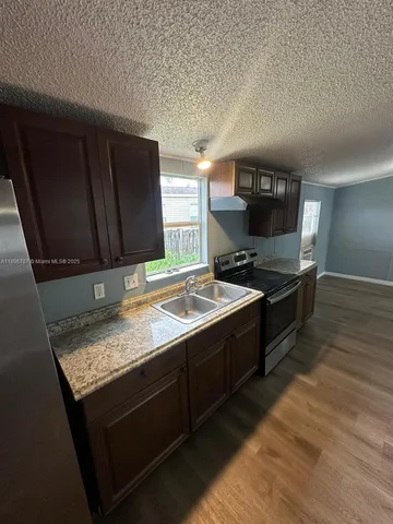 a kitchen with a sink a stove and cabinets