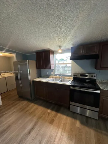 a kitchen with stainless steel appliances granite countertop a stove a refrigerator and a microwave