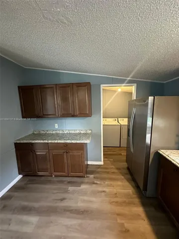 a view of a refrigerator in kitchen and wooden floor
