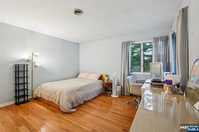 a bedroom with a bed couch and a large window