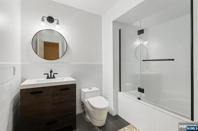 a bathroom with a sink a toilet and a mirror