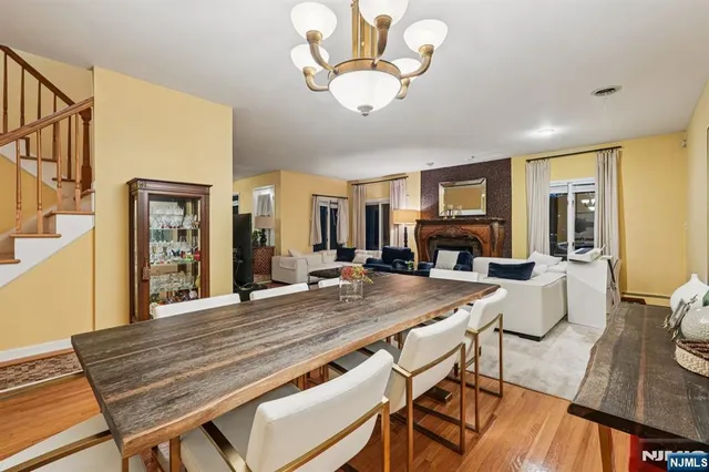 a dining room with wooden floor a chandelier a wooden table and chairs