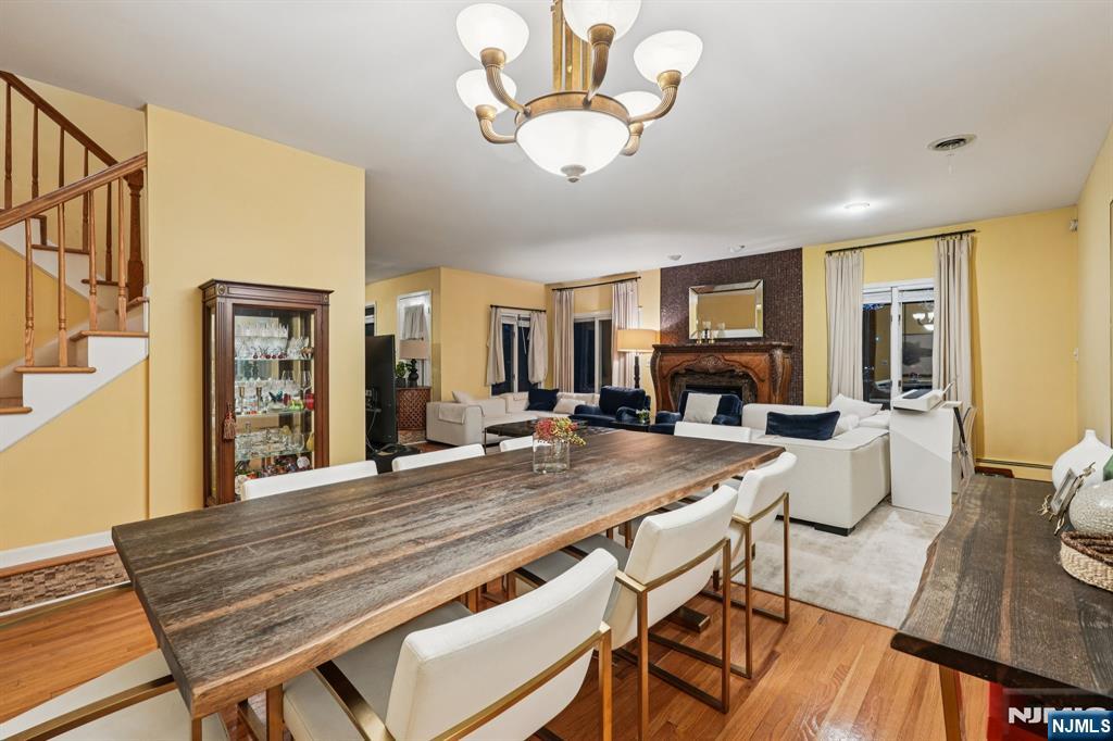 47 Matthew Road Wayne, NJ 07470 - Photo 6 of 25 a dining room with wooden floor a chandelier a wooden table and chairs