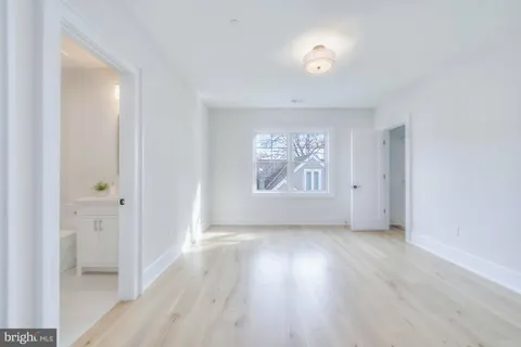a kitchen with white cabinets and a window