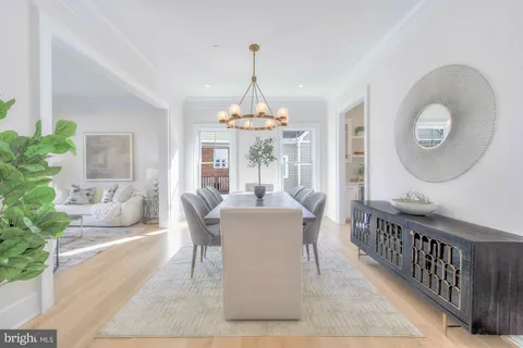 a dining room with furniture a chandelier and wooden floor