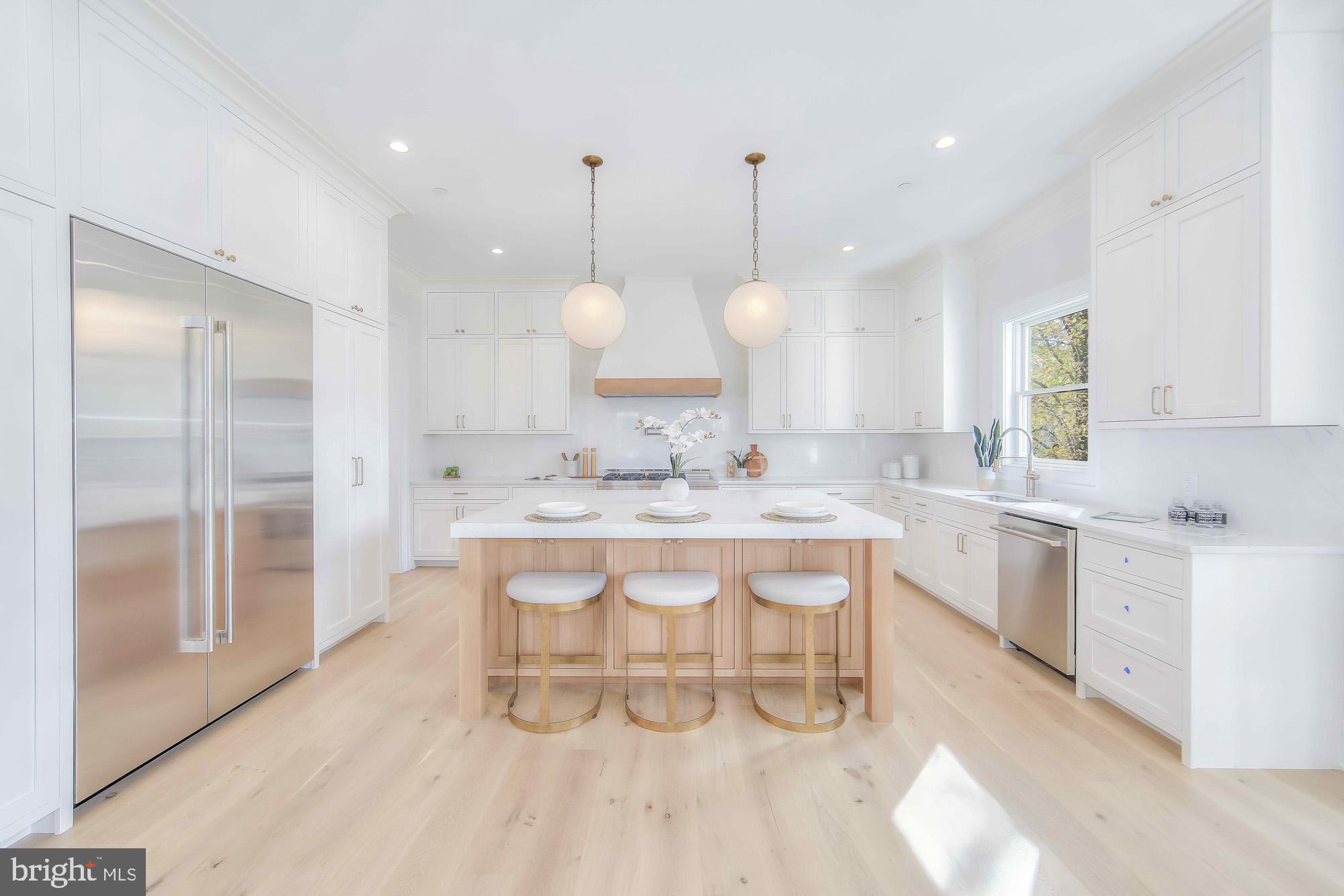 6012 Sonoma Road Bethesda, MD 20817 - Photo 9 of 57 a large white kitchen with a sink a refrigerator and a wooden floor
