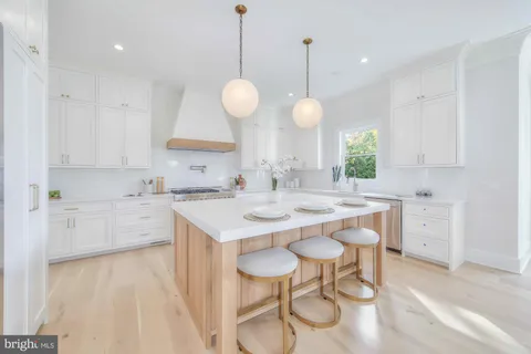a large kitchen with kitchen island white cabinets and a sink