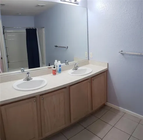 a bathroom with a double vanity sink and a mirror