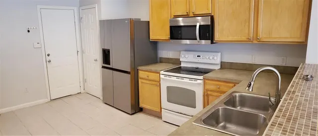 a kitchen with a refrigerator sink and cabinets
