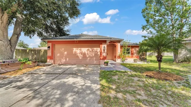 a view of a house with backyard and a tree
