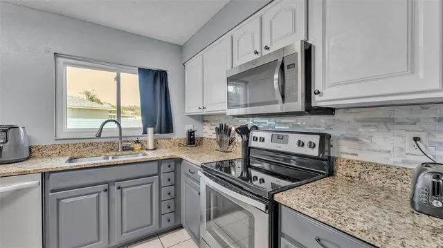 a kitchen with cabinets stainless steel appliances and a counter space