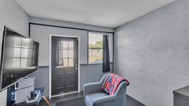 a view of a patio with table and chairs and potted plants with large tree
