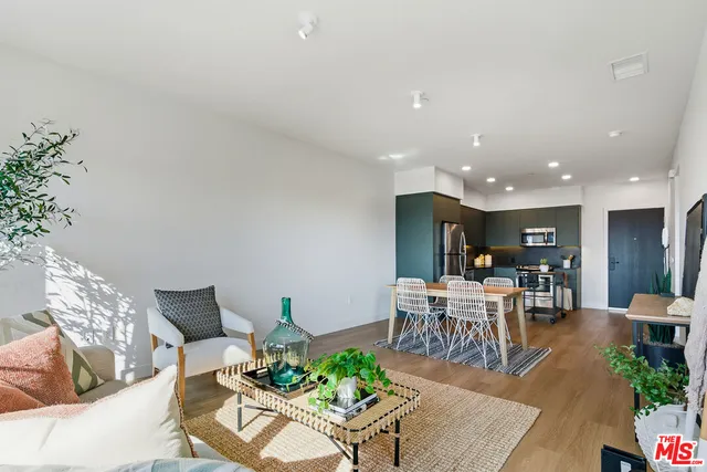 a living room with furniture a dining table and kitchen view