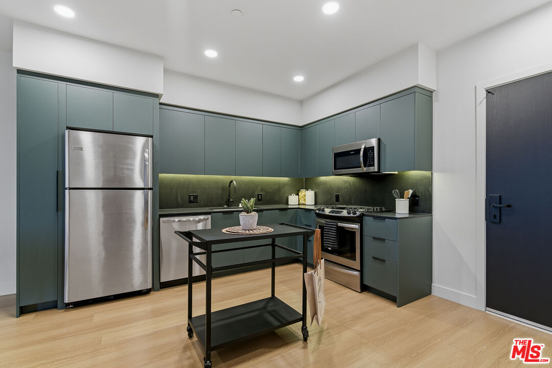 10601 Washington Boulevard, Unit 428 Culver City, CA 90232 - Photo 9 of 29 a kitchen with stainless steel appliances granite countertop a refrigerator and a stove top oven
