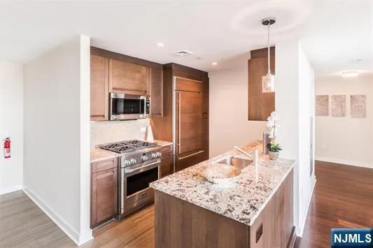 a kitchen with stainless steel appliances granite countertop a stove oven and a refrigerator