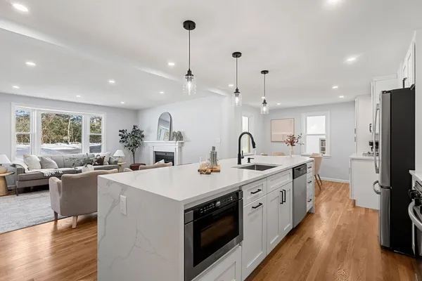 a large kitchen with stainless steel appliances a large center island attached withe living room